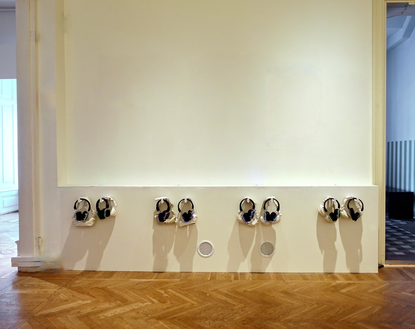 A row of headphones hanging on the wall, ready for the next visitors.