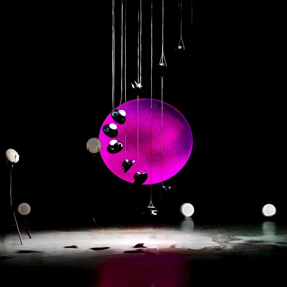 RE-BIRTH immersive spatial sound installation with suspended speakers and pink circular projection