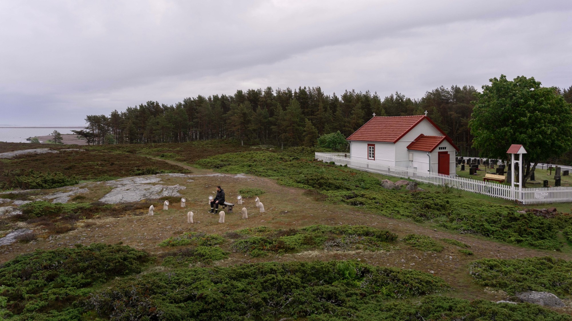 INTER, Jurmo between the chapel, cemetery and Baltic Sea landscape, with Jaakko Autio seated in the listening environment.