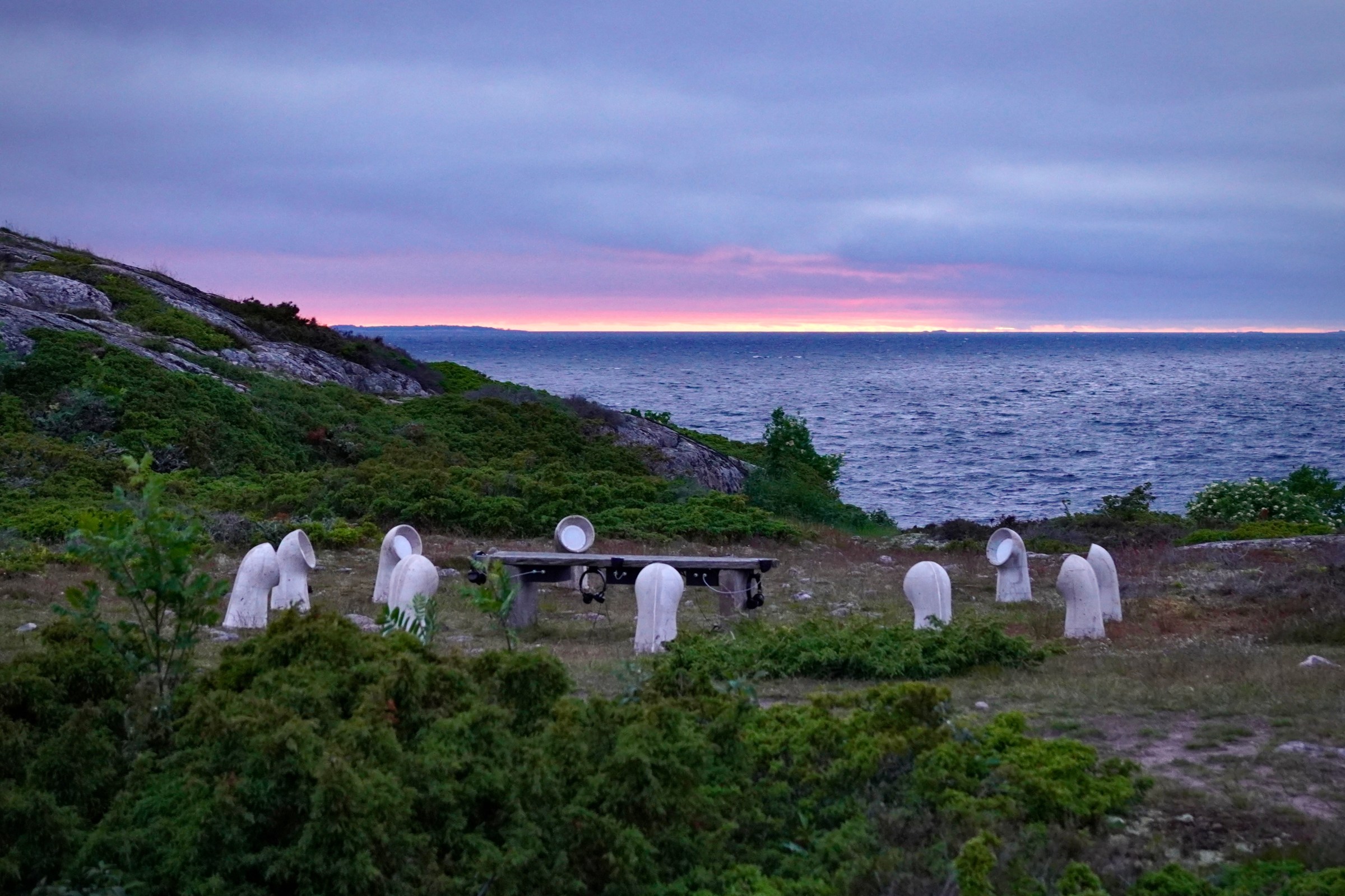 INTER, Jurmo: the listening bench and white concrete speakers by the Baltic Sea at dusk.