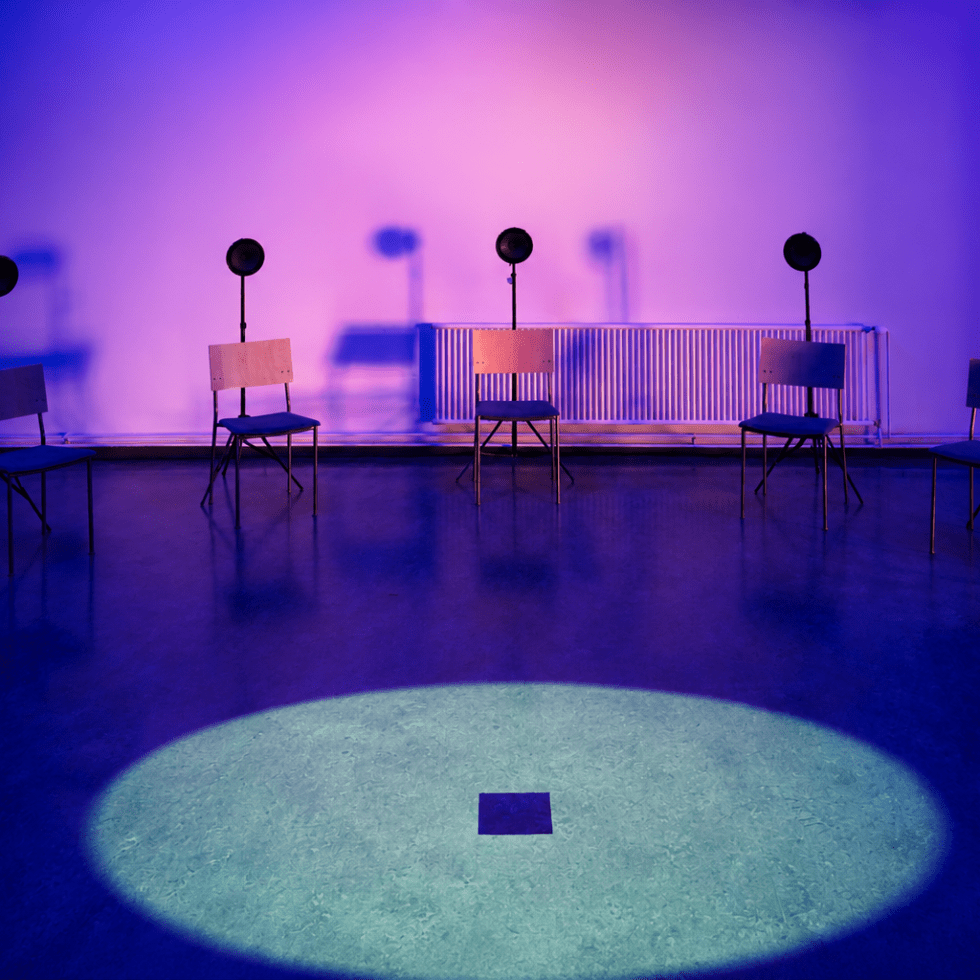 Installation view of INTER SERIES: SALATTU, a 20-channel spatial sound and video installation by Jaakko Autio at Galleria Oiva, Ylivieska. Loudspeakers surround a circular floor projection inside a blue-lit gallery space.