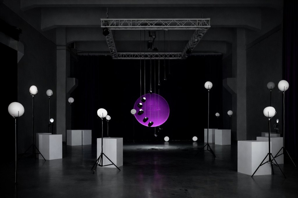RE-BIRTH at MUU Helsinki: white breath speakers on stands and plinths around the room, a column of suspended speakers in front of a round purple projection at the centre.