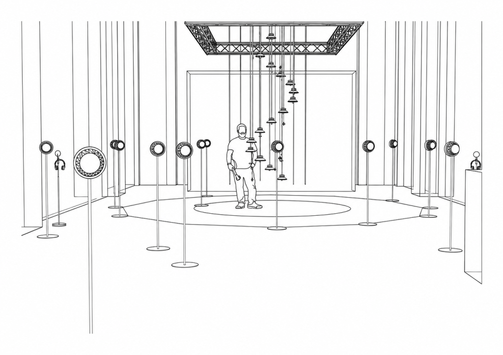 View into the RE-BIRTH room: a person stands beneath the suspended column of speakers, surrounded by a ring of speakers on stands.